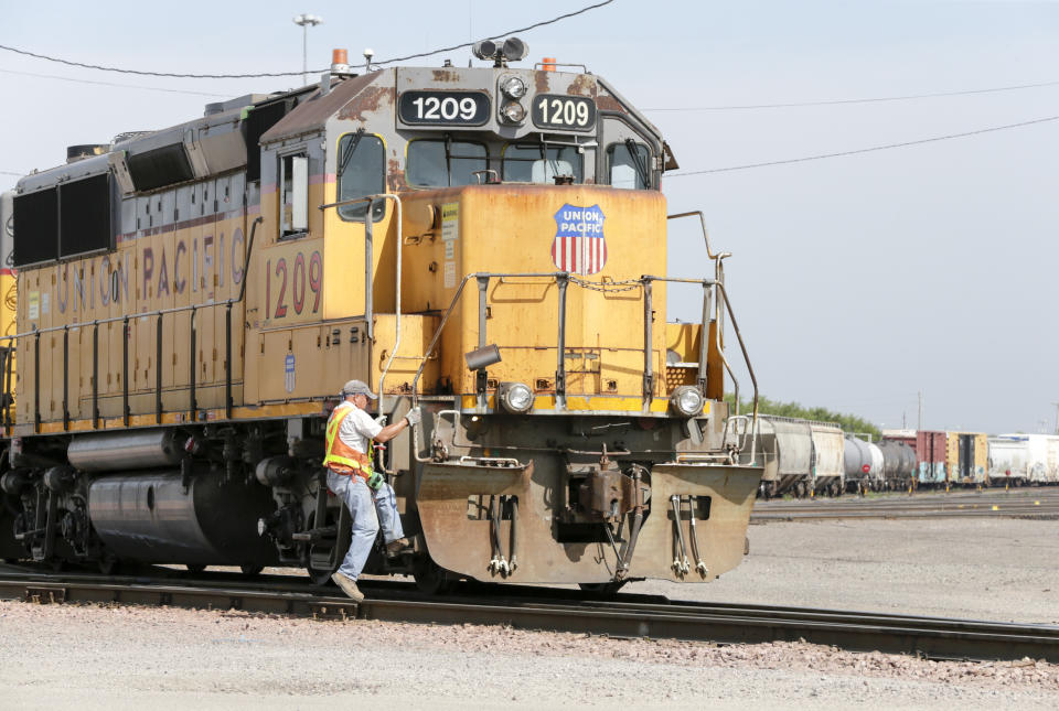 A Union Pacific employee climbs on board a locomotive in a rail yard in Council Bluffs, Iowa, Thursday, July 20, 2017. (AP Photo/Nati Harnik)