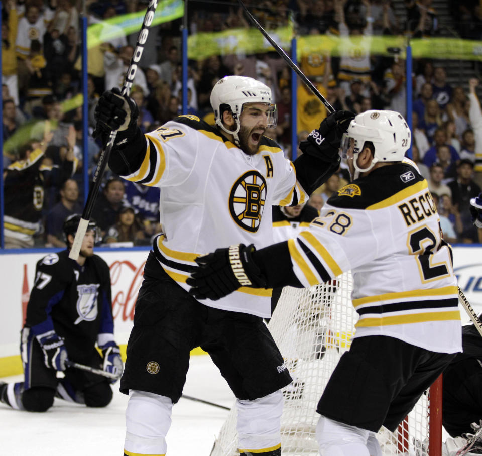 FILE - Boston Bruins center Patrice Bergeron, center, celebrates with Mark Recchi (28) after Bergeron scored against the Tampa Bay Lightning in the first period of Game 4 of the NHL hockey Stanley Cup playoff Eastern Conference final, Saturday, May 21, 2011, in Tampa, Fla. Bruins forward Patrice Bergeron has retired. The five-time Selke Trophy winner announced Tuesday, July 25, 2023, that he will not return for a 20th season with the only team he has ever played for. The Bruins captain said he is leaving with no regrets.(AP Photo/Chris O'Meara)