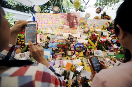 People take pictures of tributes and well-wishes to Singapore's former prime minister Lee Kuan Yew, at the Singapore General Hospital, March 23, 2015. REUTERS/Timothy Sim