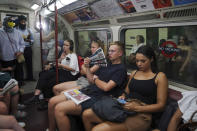A man uses a newspaper as a fan while traveling on the Bakerloo line in central London during a heat wave, Monday, July 18, 2022. (Yui Mok/PA via AP)