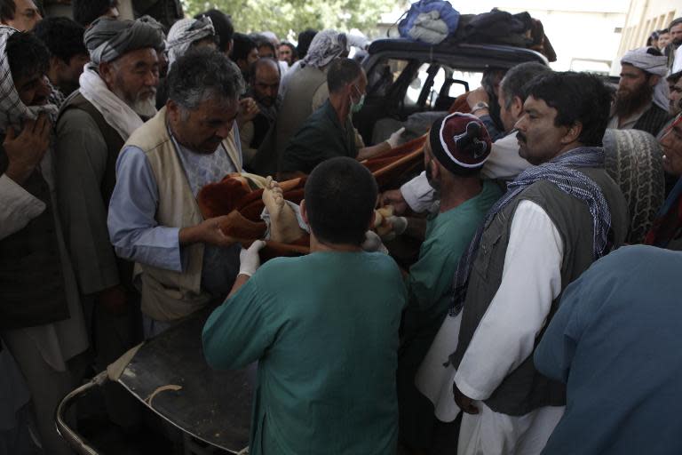 Afghan health officials carry the body of an aid worker into a hospital in Mazar-i-Sharif on June 2, 2015