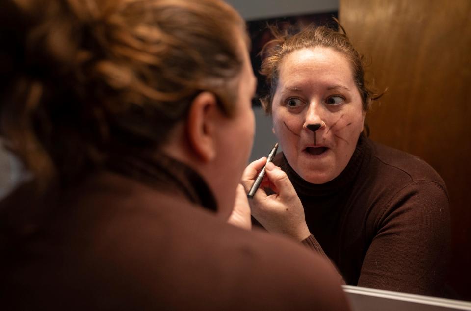 Lynn Blasey, 40, program manager of the Community Arts Partnerships office at the College for Creative Studies, stands in front of her mirror as she puts on her makeup before getting into her "Trash Squirrel" costume inside her home in Hamtramck on Saturday, March 9, 2024. "Pairing costumes with an act like cleaning up trash helps bring a sense of magic and wonder to the act of picking up trash and encourages others to join in," Blasey said.