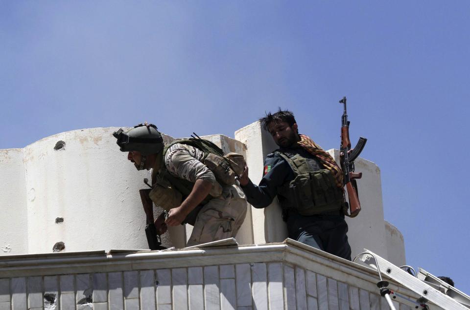 Afghan security forces take their position at the top of a residential building, where insurgents are holed up in, during an attack on the Indian consulate in Herat province May 23, 2014. (REUTERS/Mohmmad Shoib)