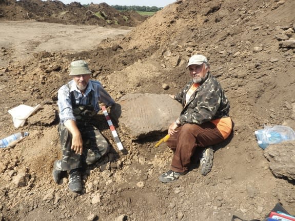 Archaeologists pose with a Bronze Age sundial dating back more than 3,000 years.