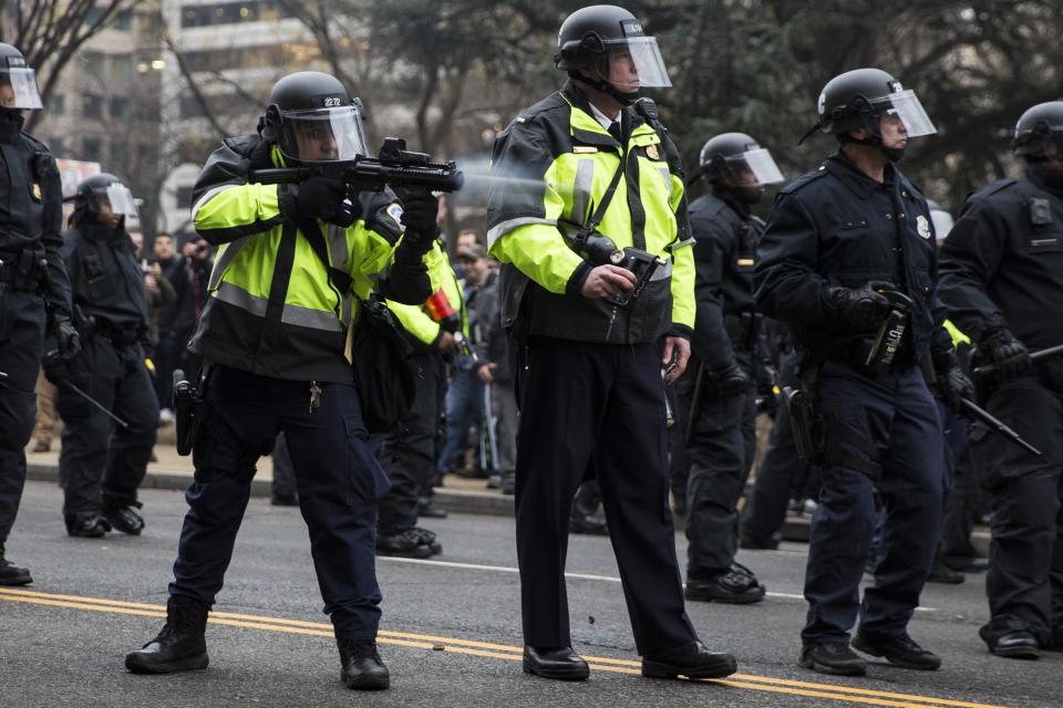 A police officer fires a beanbag round at anti-Trump protesters, Jan. 20, 2017. (Photo: Anadolu Agency via Getty Images)