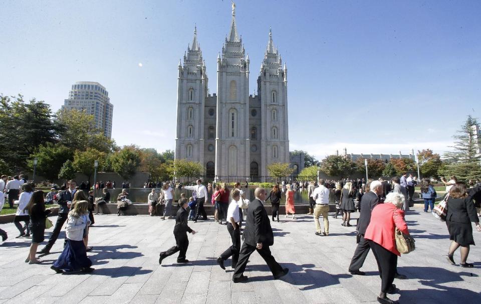 FILE - In this Oct. 5, 2013, file photo, shows people walking pass the Salt Lake Temple on the way to the Conference Center during opening session of the two-day Mormon church conference, in Salt Lake City. More than 100,000 Latter-day Saints are expected in Salt Lake City this weekend for the church's biannual general conference. Leaders of The Church of Jesus Christ of Latter-day Saints give carefully crafted speeches aimed at providing members with guidance and inspiration in five sessions that span Saturday and Sunday. They also make announcements about church statistics, new temples or initiatives. In addition to those filling up the 21,000-seat conference center during the sessions, thousands more listen or watch around the world in 95 languages on television, radio, satellite and Internet broadcasts. A Mormon's women group pushing the church to allow women in the priesthood plans to demonstrate outside an all-male meeting Saturday. The church has asked them to reconsider, and barred media from going on church property during the demonstration. (AP Photo/Rick Bowmer, File)