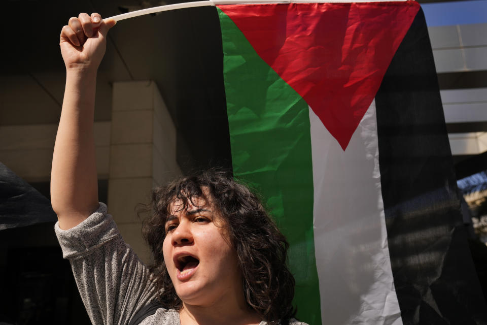 A woman holds up a Palestinian flag as she shouts slogans during a protest to support the Palestinian women on the International Women's Day outside the office of a U.N. organisation, in Beirut, Lebanon, Friday, March 8, 2024. The U.N. agency for Palestinian refugees says about 9,000 women have been killed in the Gaza Strip since the Israel-Hamas war began five months ago. (AP Photo/Hussein Malla)