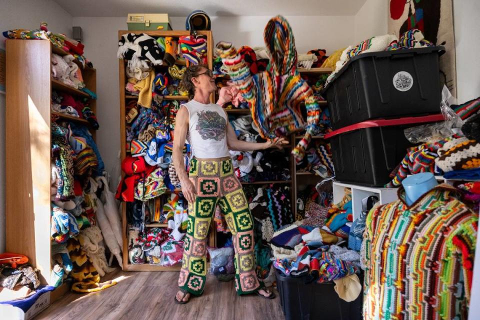 Fashion designer Schuyler Ellers tosses a hoodie made from found crochet blankets at his studio near Nevada City earlier this month. His clothing line, Lord von Schmitt, is made from crochet blankets and throws.