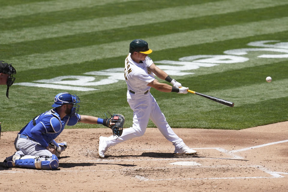 Oakland Athletics' Matt Chapman, right, hits a two-run double in front of Kansas City Royals catcher Cam Gallagher during the second inning of a baseball game in Oakland, Calif., Saturday, June 12, 2021. (AP Photo/Jeff Chiu)