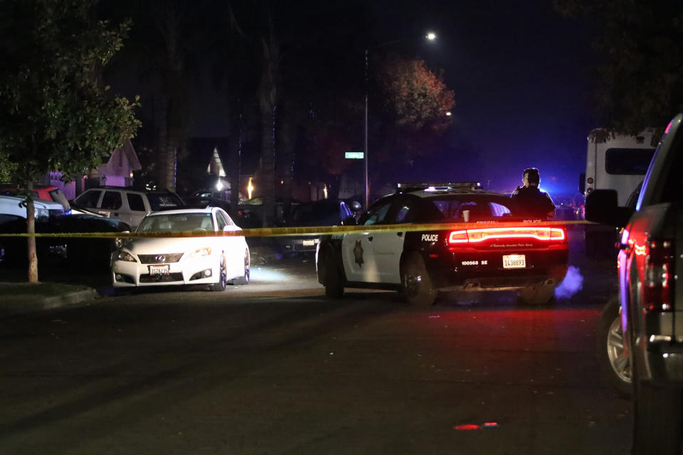 Police work at the scene of a shooting, Sunday, Nov. 17, 2019, in southeast Fresno, Calif. Multiple people were shot and at least four of them were killed Sunday at a party in Fresno when suspects sneaked into the backyard and fired into the crowd, police said. (Larry Valenzuela/The Fresno Bee via AP)