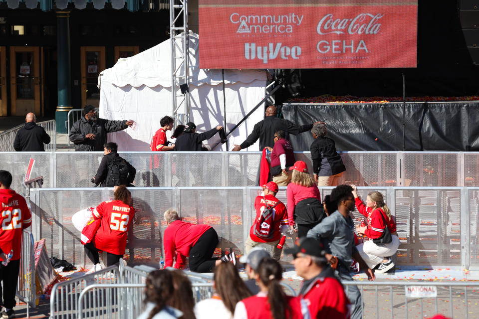 People take cover during the shooting at the Super Bowl victory parade on Wednesday.