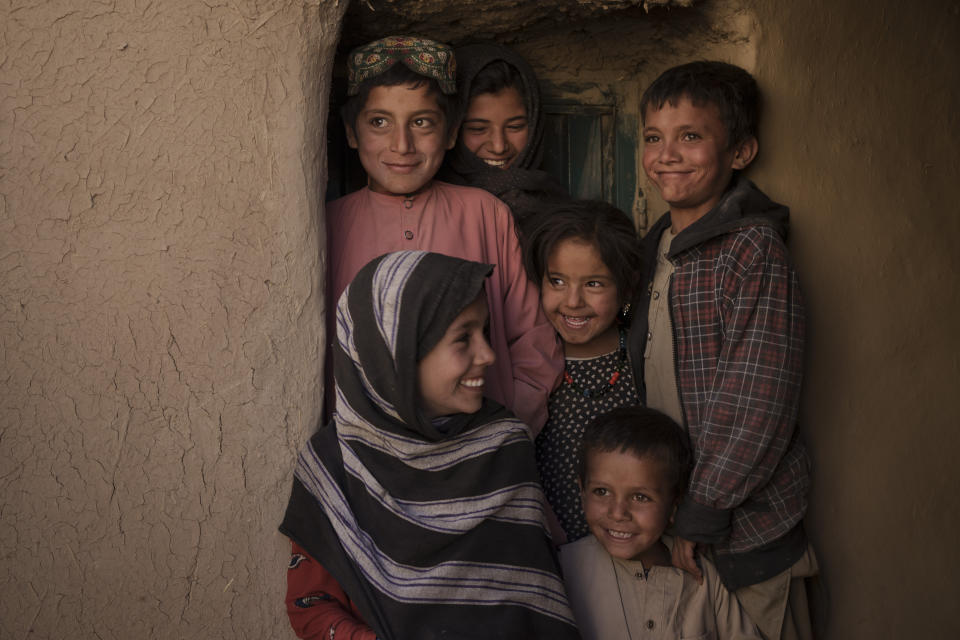 Mina Ahmed's children and relatives laugh as they pose for a photo in their house at Salar village, Wardak province, Afghanistan, Tuesday, Oct. 12, 2021. In urban centers, public discontent toward the Taliban is focused on threats to personal freedoms, including the rights of women. In Salar, these barely resonate. The ideological gap between the Taliban leadership and the rural conservative community is not wide. Many villagers supported the insurgency and celebrated the Aug. 15 fall of Kabul which consolidated Taliban control across the country. (AP Photo/Felipe Dana)