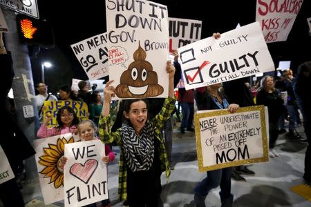 People hold signs as they rally for the permanent shut down of the Aliso Canyon natural gas storage facility near the Porter Ranch neighborhood in Los Angeles, California February 19, 2016. REUTERS/Mario Anzuoni