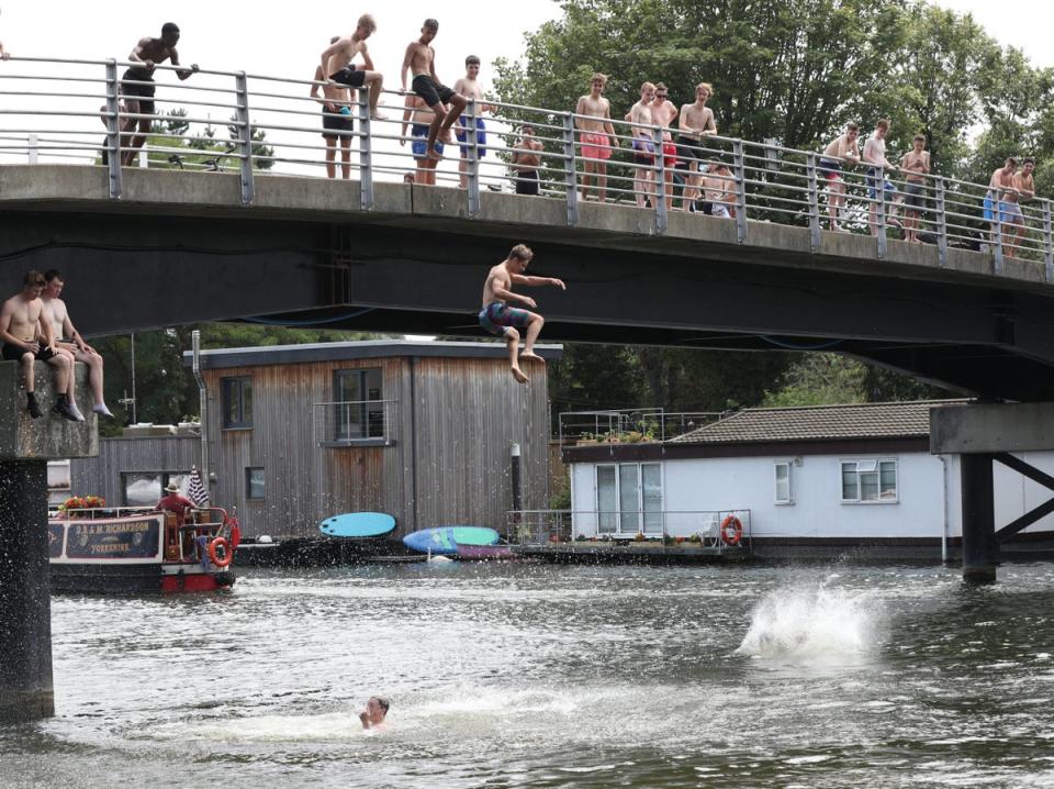 Surrey: People leap from a bridge at Taggs Island, near Hampton Court (PA)