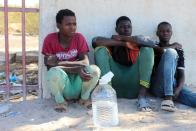 Migrants are seen on the street, after being rescued by the Libyan coast guard, in Misrata