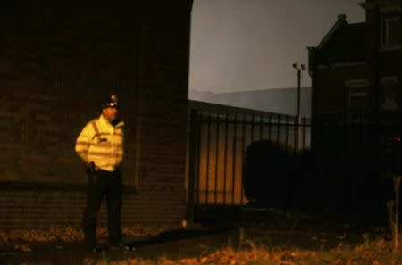 A police officer stands on duty as smoke emerges from the rear of Winson Green prison, run by security firm G4S, after a serious disturbance involving some 300 inmates broke out, in Birmingham, Britain, December 16, 2016. REUTERS/Peter Nicholls