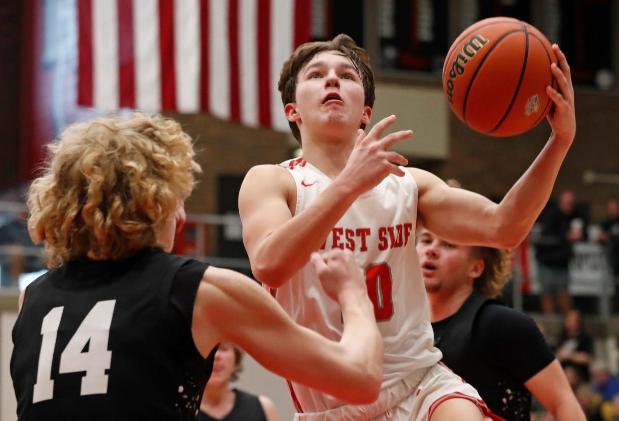 West Lafayette Red Devils Ben Werth (10) shoots the ball over Peru Tigers forward Xavier Turner (14) during the IHSAA boys basketball regional championship game, Saturday, March 9, 2024, at Logansport High School in Logansport, Ind. Peru won 62-46.