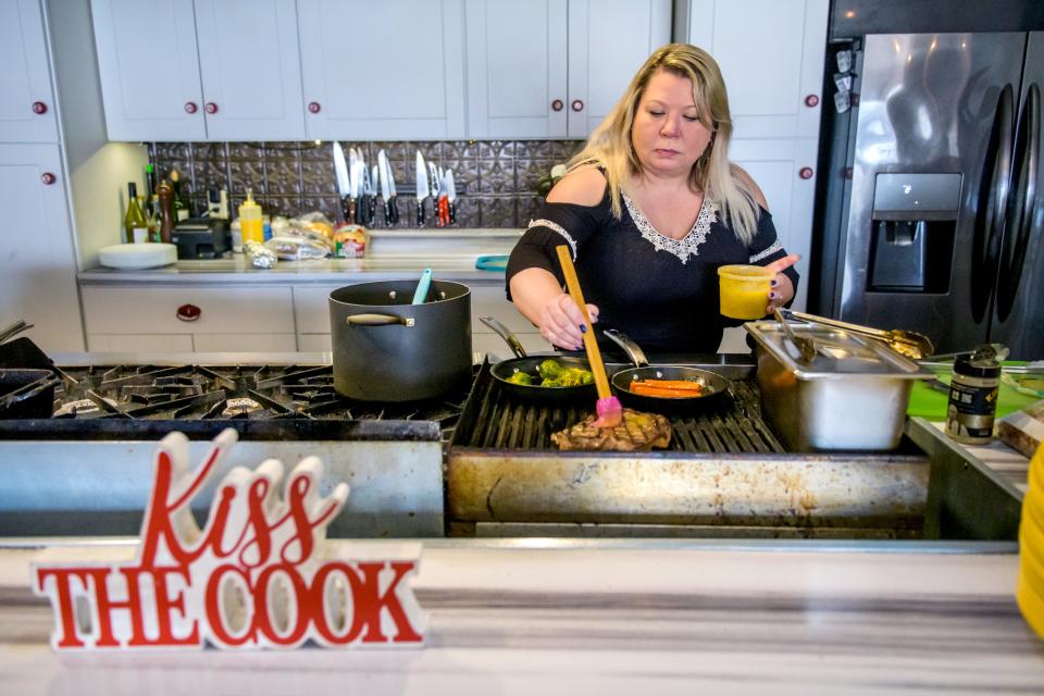 Rebecca Hearn, owner and head chef of Untamed Chef, 7338 N. University St., bastes a rib-eye in the kitchen at the Peoria restaurant.