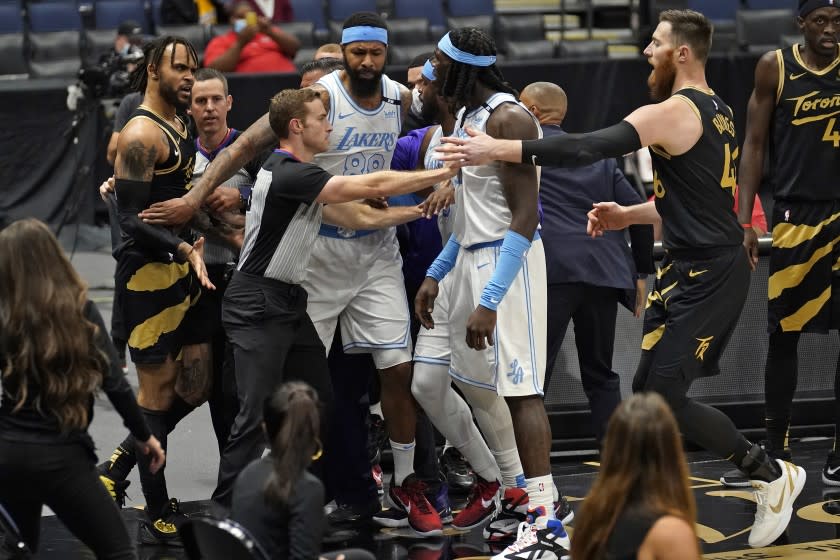 RETRANSMISSION TO CORRECT LAKERS PLAYER WHO WAS EJECTED TO MONTREZL HARRELL - Officials separate Toronto Raptors guard Gary Trent Jr. (33) and Los Angeles Lakers center Montrezl Harrell (15) after Raptor's OG Anunoby (3) threw Lakers' Dennis Schroder (17) to the floor after a foul during the first half of an NBA basketball game Tuesday, April 6, 2021, in Tampa, Fla. Toronto Raptors OG Anunoby and Los Angeles Lakers Montrezl Harrell were ejected.(AP Photo/Chris O'Meara)