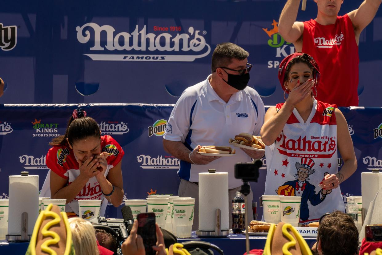 Competitive eaters Michelle Lesco (L), the new women's champion, and second-place winner Sarah Rodriguez (R) eat hot dogs at the 2021 Nathan's Famous 4th Of July International Hot Dog Eating Contest on July 4, 2021, in New York City.