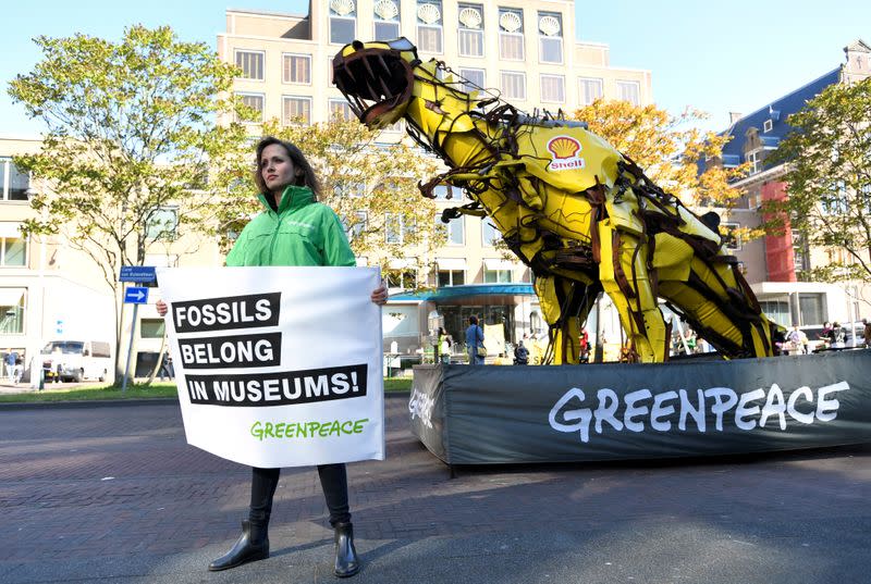 Protester holds a banner during a demonstration outside of the Shell headquarters, in The Hague