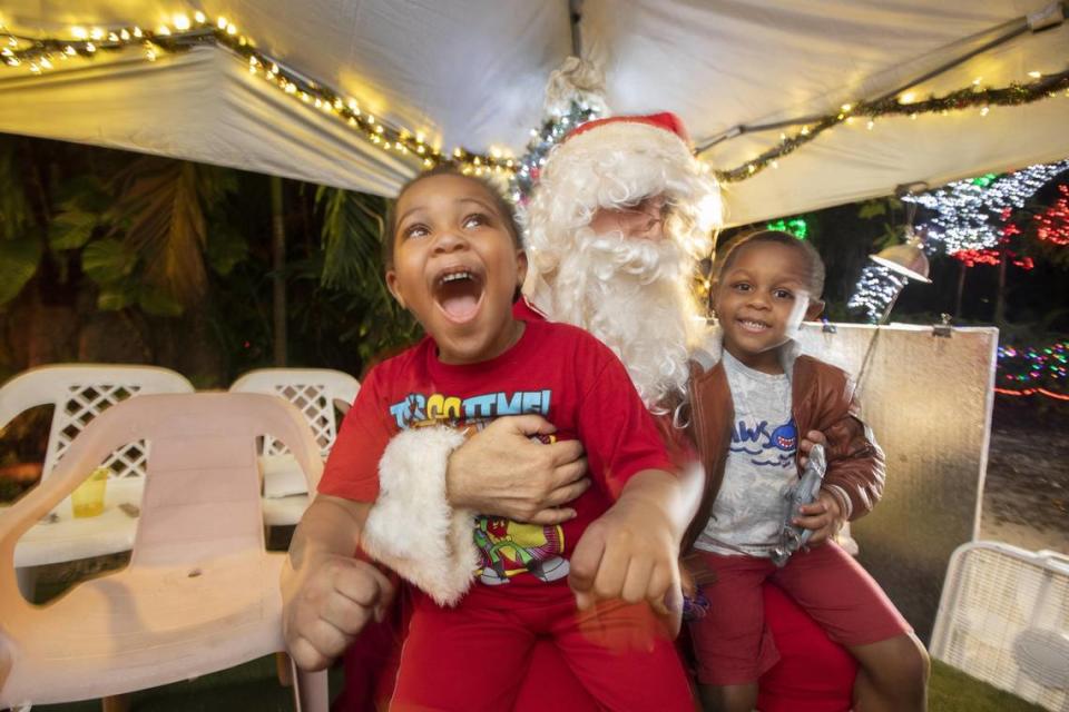 KhaâTyi Macillon, 5, and AhâMier Macillon, 3, enjoy a visit with Santa Tuesday at a neighborhood of decorated homes known as the Enchanted Place in North Miami, 1600 NE 137th Terrace. 
