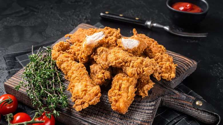 breaded chicken on wooden tray 