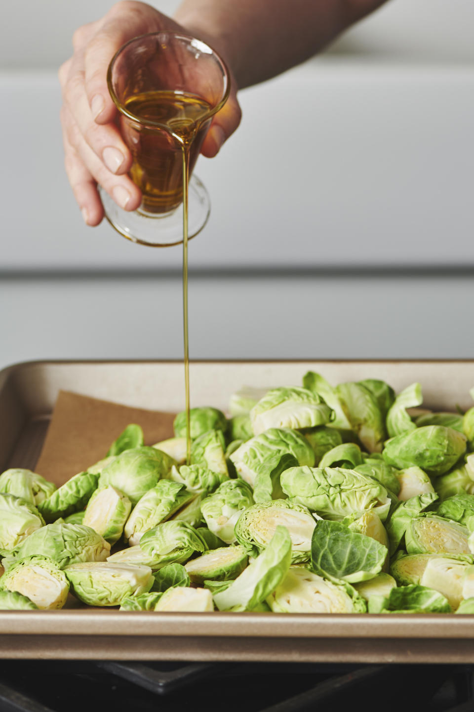 This image provided by Cheyenne Cohen shows olive oil being poured onto Brussel sprouts. Brussels sprouts are often cooked as a side dish, especially during the cold weather months. They are particularly popular as part of holiday meals such as Thanksgiving and Christmas. And if you think you don't like Brussels sprouts, I'm here to say AP food writer Katie Workman says you just haven't had them prepared well. (Cheyenne Cohen via AP)