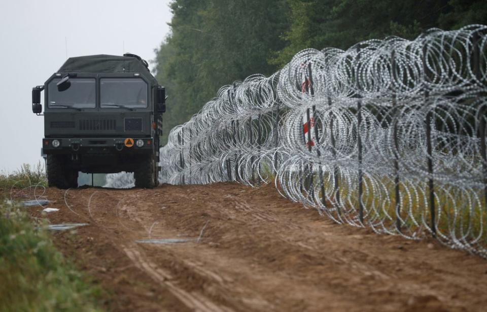 A view of a vehicle next to a fence built by Polish soldiers on the border between Poland and Belarus (REUTERS)