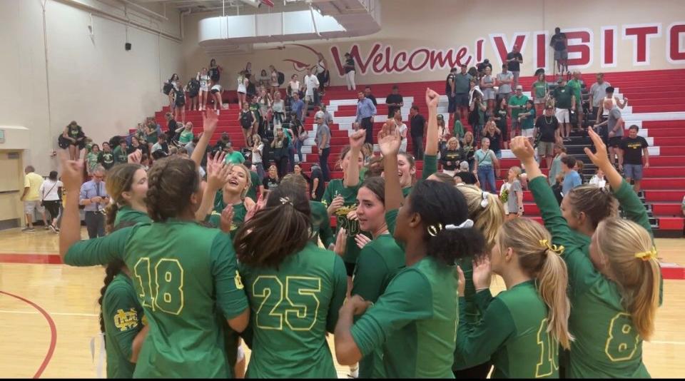 A volleyball team celebrates.