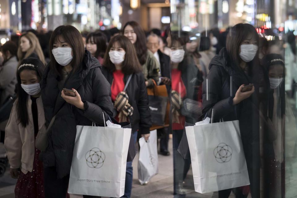 People wearing masks walk through the Ginza shopping district (Getty Images)