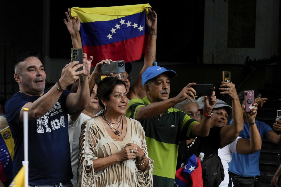 Simpatizantes del candidato presidencial de oposición Edmundo González miran al aspirante y a la líder opositora María Corina Machado a su paso en un acto de inicio de la campaña política ante las elecciones presidenciales del 28 de julio en Caracas, Venezuela, el jueves 4 de julio de 2024. (AP Foto/Ariana Cubillos)