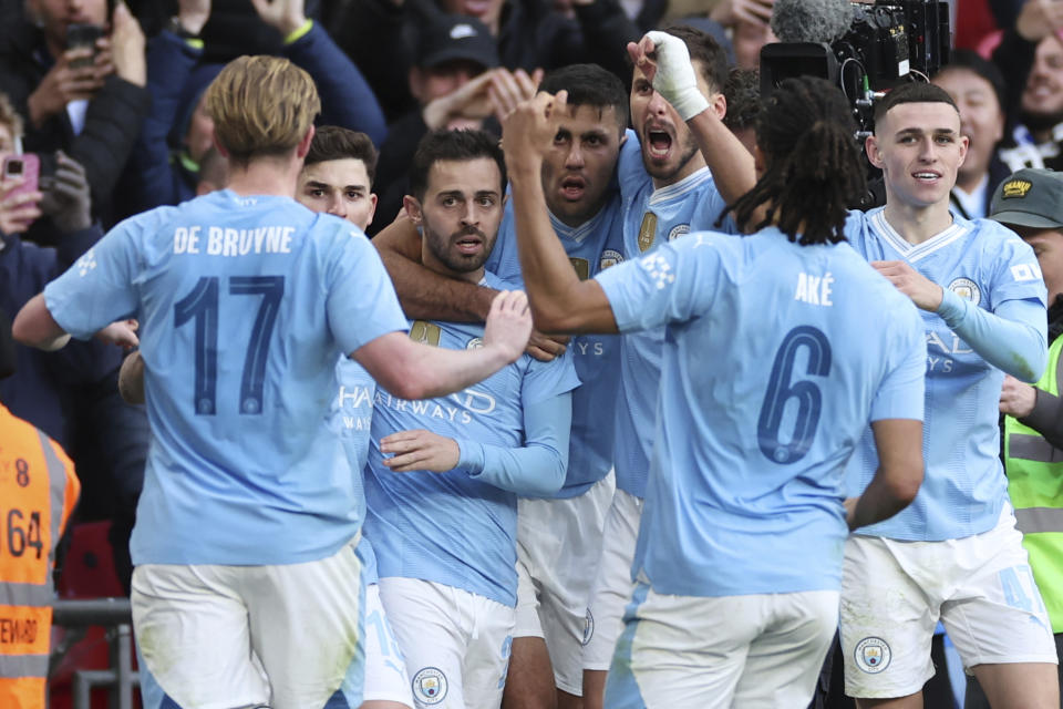 Manchester City's Bernardo Silva, center left, celebrates after scoring his side's opening goal during the English FA Cup semifinal soccer match between Manchester City and Chelsea at Wembley stadium in London, Saturday, April 20, 2024. (AP Photo/Ian Walton)