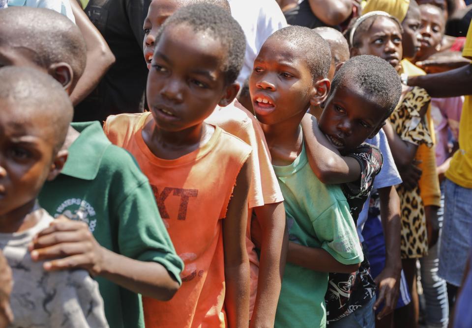 Varios niños hacen fila para recibir comida en un albergue para familias desplazadas por la violencia de las pandillas, en Puerto Príncipe, Haití, el 14 de marzo de 2024. (AP Foto/Odelyn Joseph)