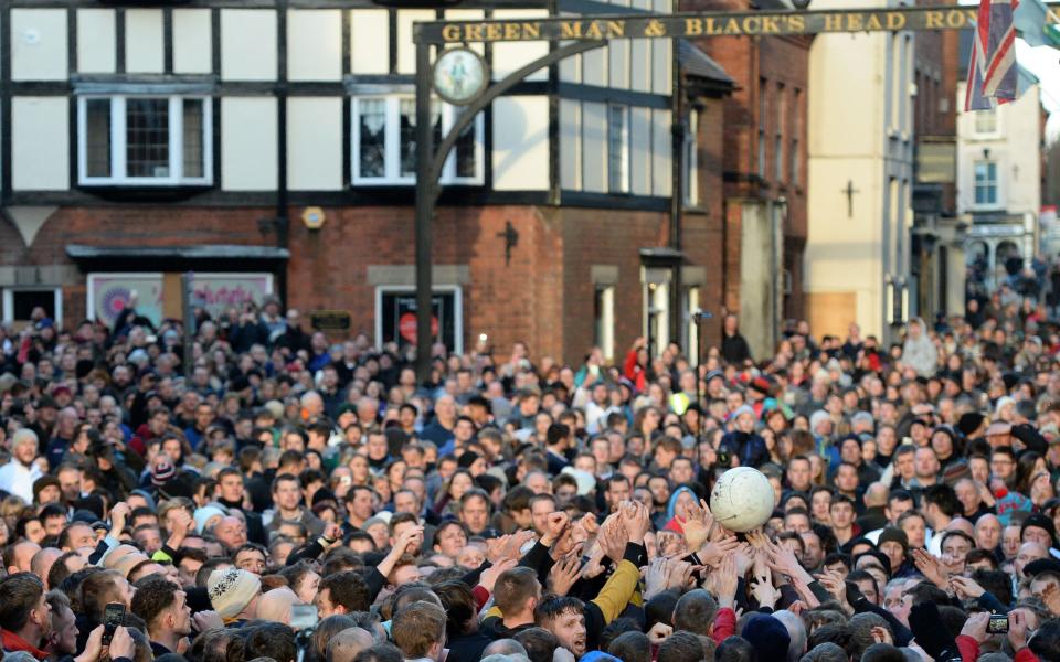 Competitors reach for the ball during the annual Royal Shrovetide Football Match in Ashbourne -  AFP/Getty Images