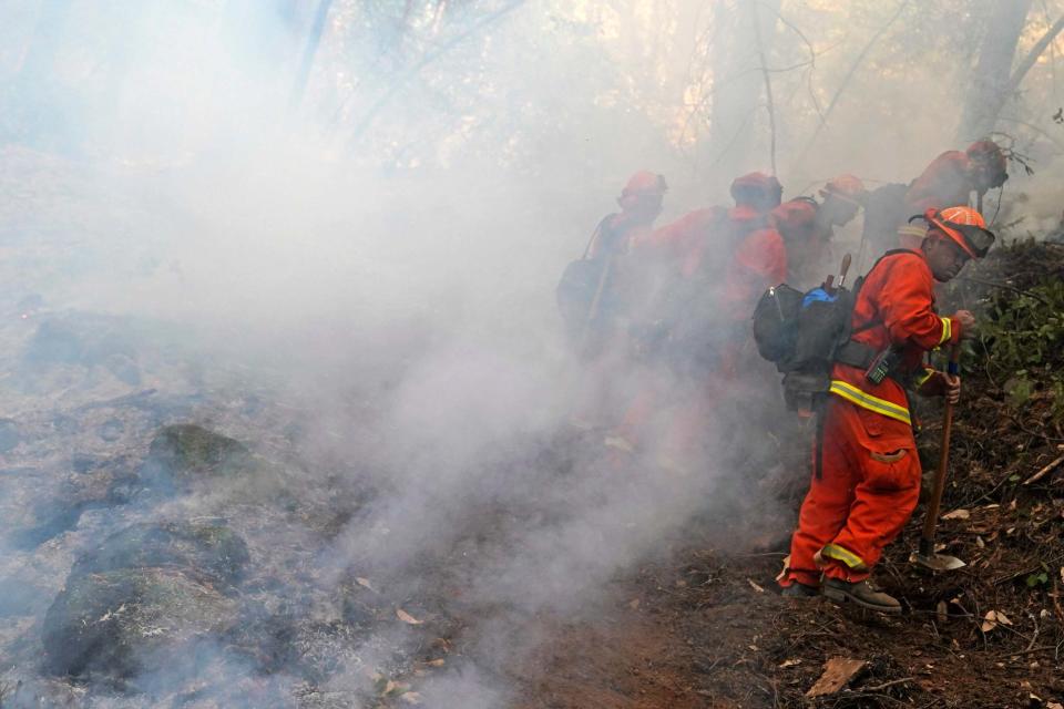 A fire crew cuts a containment line while fighting the CZU August Lightning Complex Fire (AP)