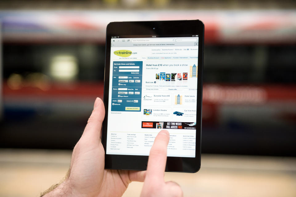 A close-up of a man accessing thetrainline.com on an Apple iPad Mini tablet computer at London's Paddington Station on January 14, 2013. Photo by Will Ireland/Future Publishing via Getty Images