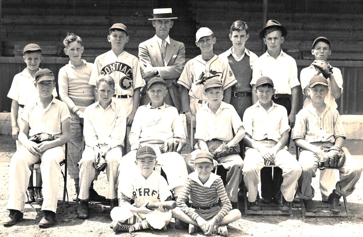 Si Siman, in Cardinals uniform, poses for a photo with his youth baseball league in Springfield, Missouri.