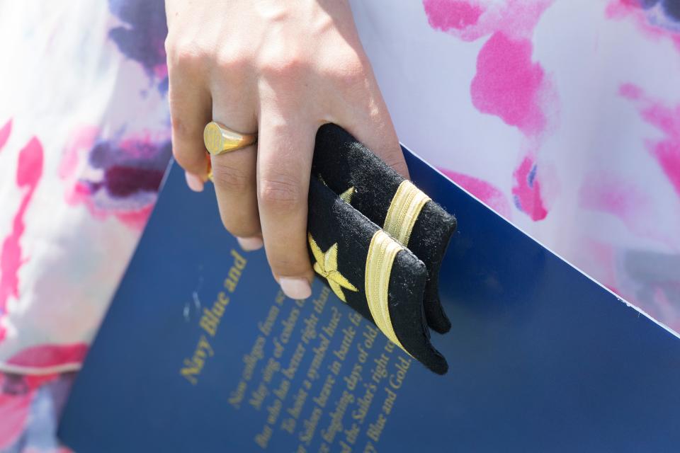 <p>A family member holds the shoulder boards for a United States Naval Academy graduate during a ceremony in Annapolis, Md., on May 25, 2018. (Photo: Jim Watson/AFP/Getty Images) </p>