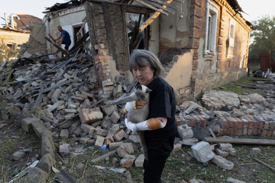 Injured Ludmila Ivanchuk, 61, holds her cat "Vasia" in front of her house, which was damaged by a Russian rocket attack in Kostiantynivka, Donetsk region, Ukraine, Sept. 27, 2023.