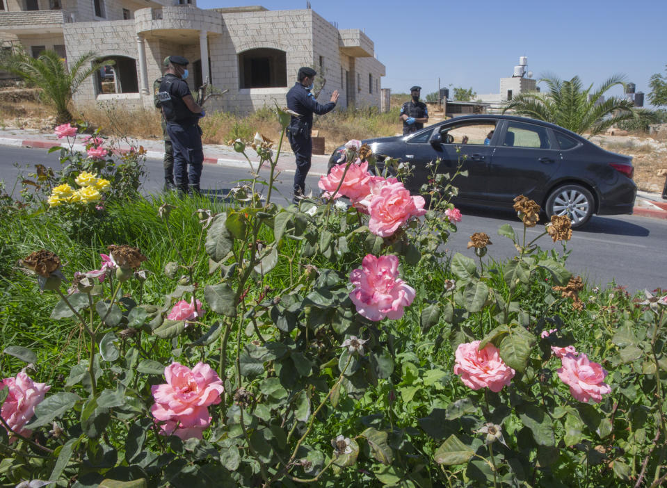 A Palestinian security unit mans a checkpoint at an entrance of in the West Bank city of Ramallah, Thursday, July 2, 2020. The Palestinian Authority has announced a five-day total lockdown in the West Bank starting Friday, in response to a major increase in coronavirus cases and deaths in recent days. (AP Photo/Nasser Nasser)