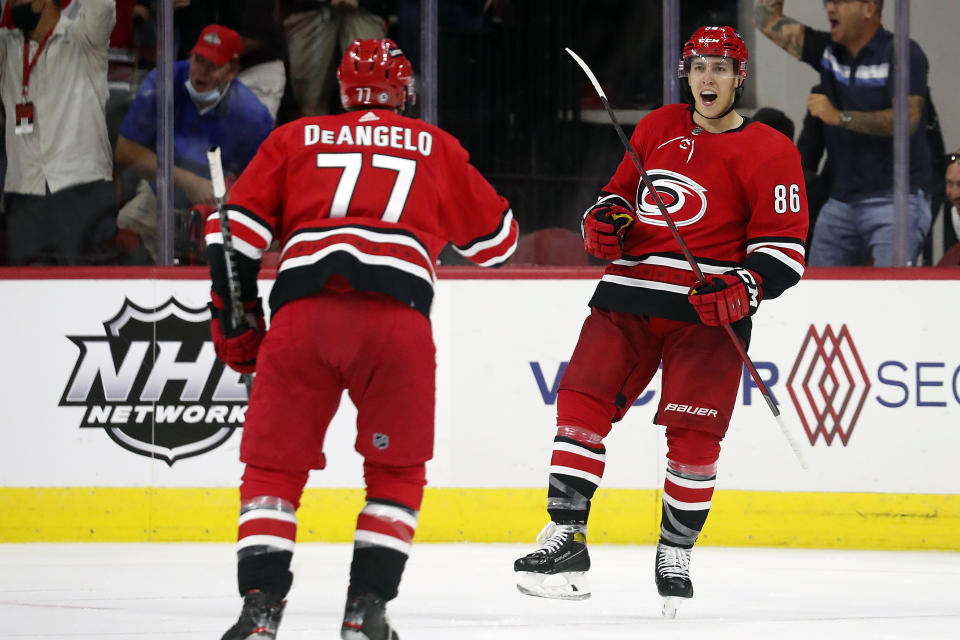 Carolina Hurricanes' Teuvo Teravainen (86) celebrates his goal with teammate Tony DeAngelo (77) during the third period of an NHL hockey game against the New York Islanders in Raleigh, N.C., Thursday, Oct. 14, 2021. (AP Photo/Karl B DeBlaker)