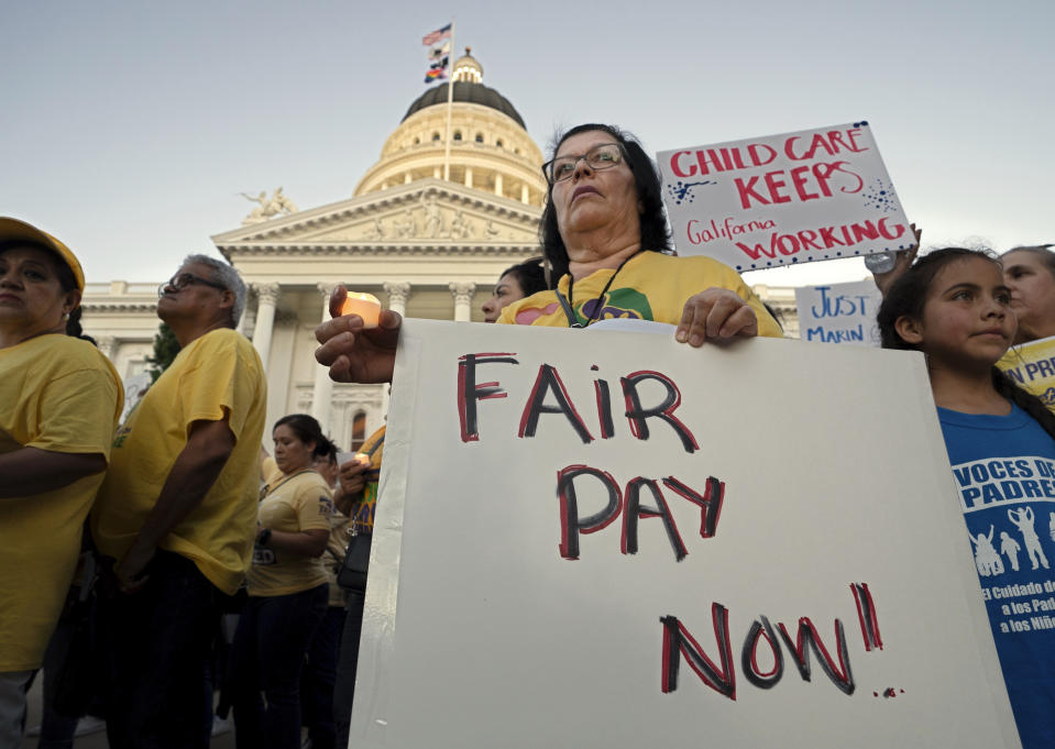 Child care workers and their supporters hold a candlelight vigil against proposed budget cuts to state provided social safety net programs, at the Capitol in Sacramento, Calif., Tuesday, June 11,2024. The California Legislature on Thursday, June 13, rejected many of Gov. Gavin Newsom's most difficult budget cuts, choosing instead to speed-up a temporary tax increase on some businesses to help pay off an estimated $45 billion deficit while preserving spending on many social safety net programs. (AP Photo/Rich Pedroncelli)