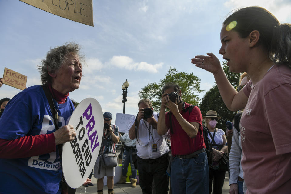 Una activista antiaborto, a la izquierda, y una defensora del derecho al aborto afuera de la Corte Suprema tras la filtración de un borrador del dictamen que muestra que la Corte Suprema podría haber votado para anular el fallo del caso Roe contra Wade, en Washington, el 3 de mayo de 2022. (Kenny Holston/The New York Times)
