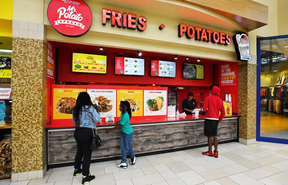 Lakita Spann takes a customer's order at the Orange Park Mall location of Mr. Potato Spread on Wednesday. She and her husband, Aaron, a chef, founded the restaurant that has two locations and a food truck.