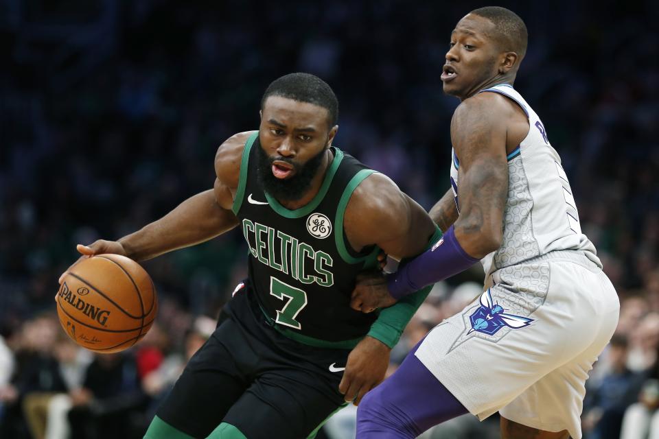 Boston Celtics' Jaylen Brown (7) drives past Charlotte Hornets' Terry Rozier, right, during the first half of an NBA basketball game in Boston, Sunday, Dec. 22, 2019. (AP Photo/Michael Dwyer)