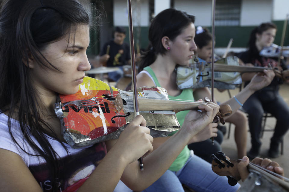 In this Dec. 11, 2012 photo, Ana Meza, 16, plays a violin made of recycled materials as she attends a practice session with “The Orchestra of Instruments Recycled From Cateura” in Cateura, a vast landfill outside Paraguay's capital of Asuncion, Paraguay. After years of practice, the youngsters of “The Orchestra of Instruments Recycled From Cateura” have begun to perform internationally, with sponsors paying their way to places like Brazil, Panama and Colombia. They hope to play at an exhibit opening next year in their honor at the Musical Instrument Museum in Phoenix, Arizona. (AP Photo/Jorge Saenz)