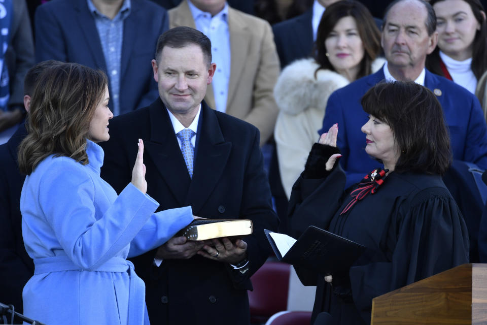 Kentucky Supreme Court Justice Debra Hembree Lambert, right, gives the oath of office to Ky. Lt. Governor Jacqueline Coleman as her husband Chris O'Bryan holds the Bible during her public swearing in ceremony on the steps of the Kentucky State Capitol in Frankfort, Ky., Tuesday, Dec. 12, 2023. (AP Photo/Timothy D. Easley)