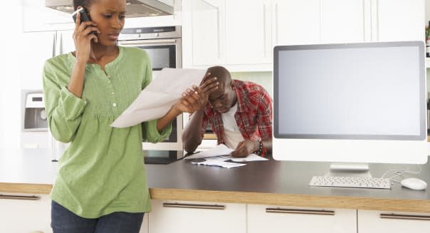 Young Couple Discussing Personal Finances In Modern Kitchen