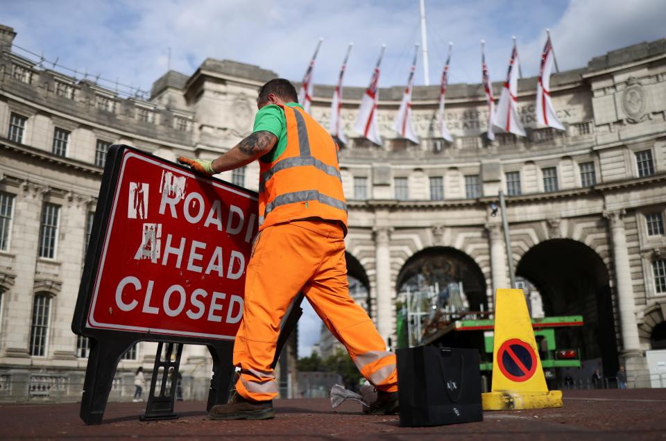 A man moves a "road closed" sign after Queen Elizabeth's funeral